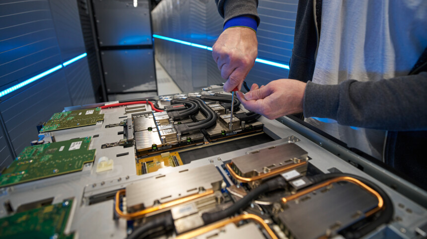 Techniker repariert Serverhardware in einem Rechenzentrum mit blauer LED-Beleuchtung.