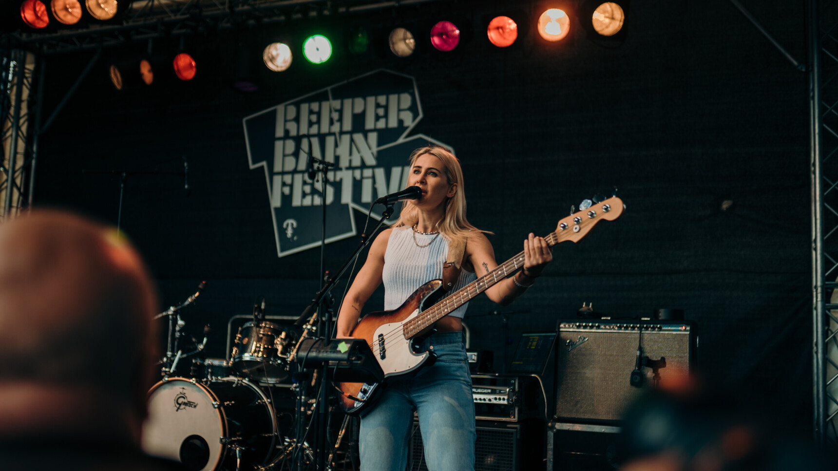 Eine Musikerin spielt Bassgitarre und singt auf der Bühne des Reeperbahn Festivals.